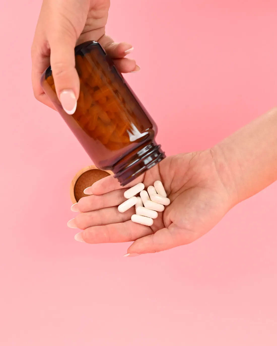 Pills being poured from a bottle into an open hand