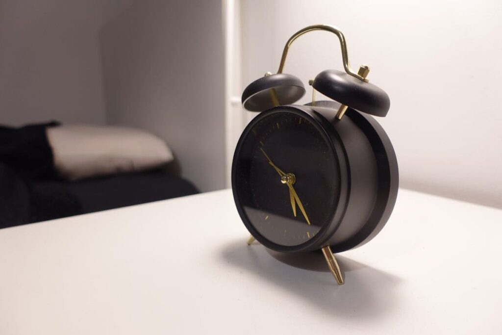 Black alarm clock on a bedside table
