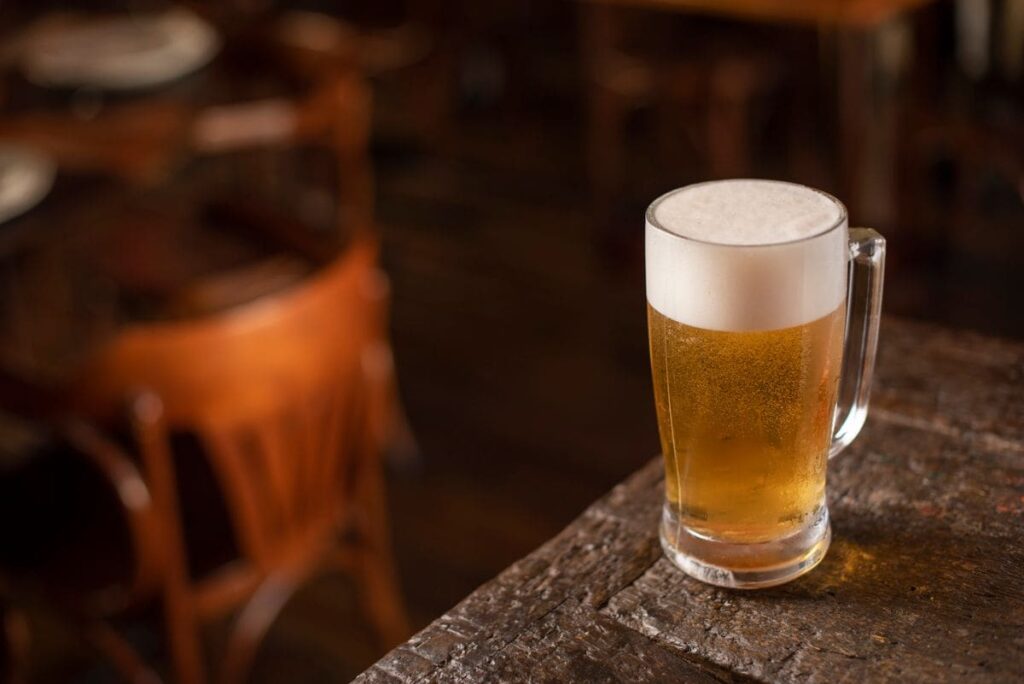 Glass of beer on a wooden pub table