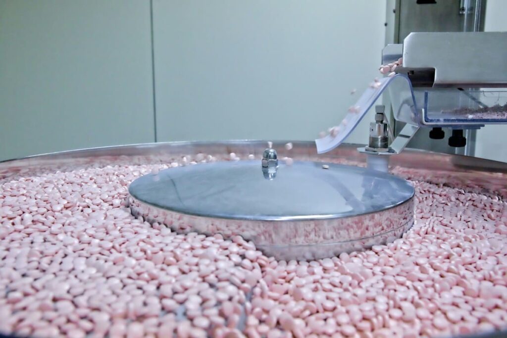 Pills moving along a machine in a medicine factory