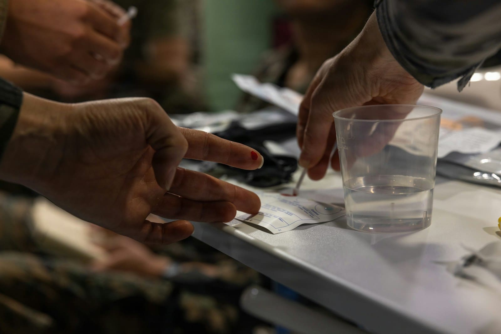 Drop of blood from a fingertip being applied to a rapid test card