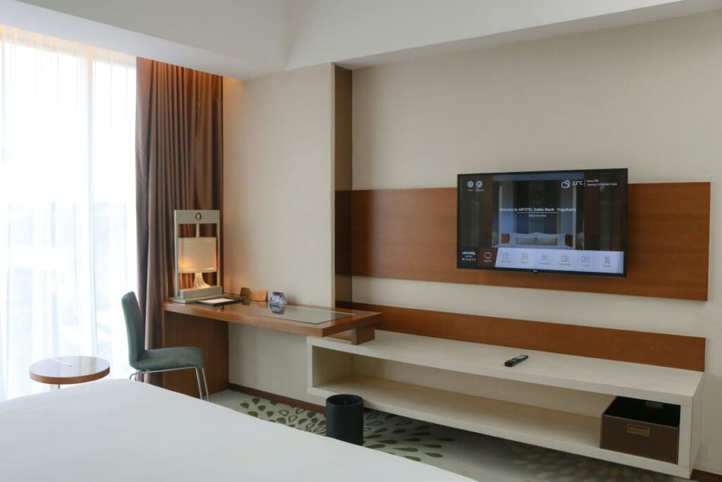 Hotel room with a desk area and a flat-screen TV