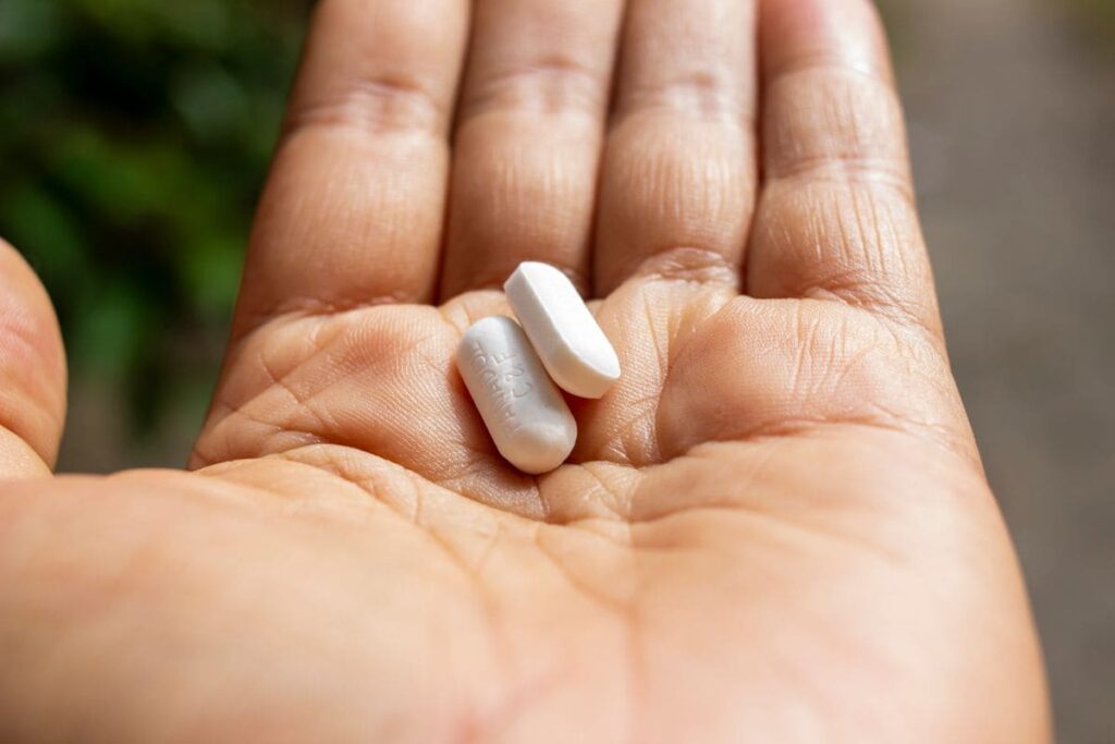 Two pills held in an open palm