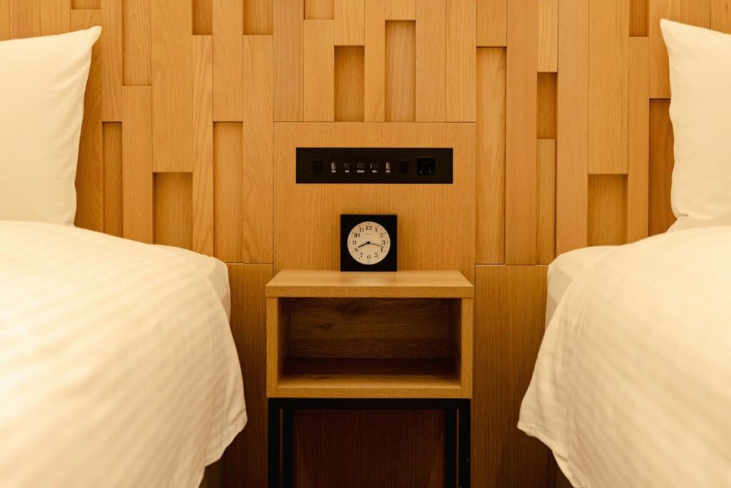 Hotel nightstand with a clock between two beds