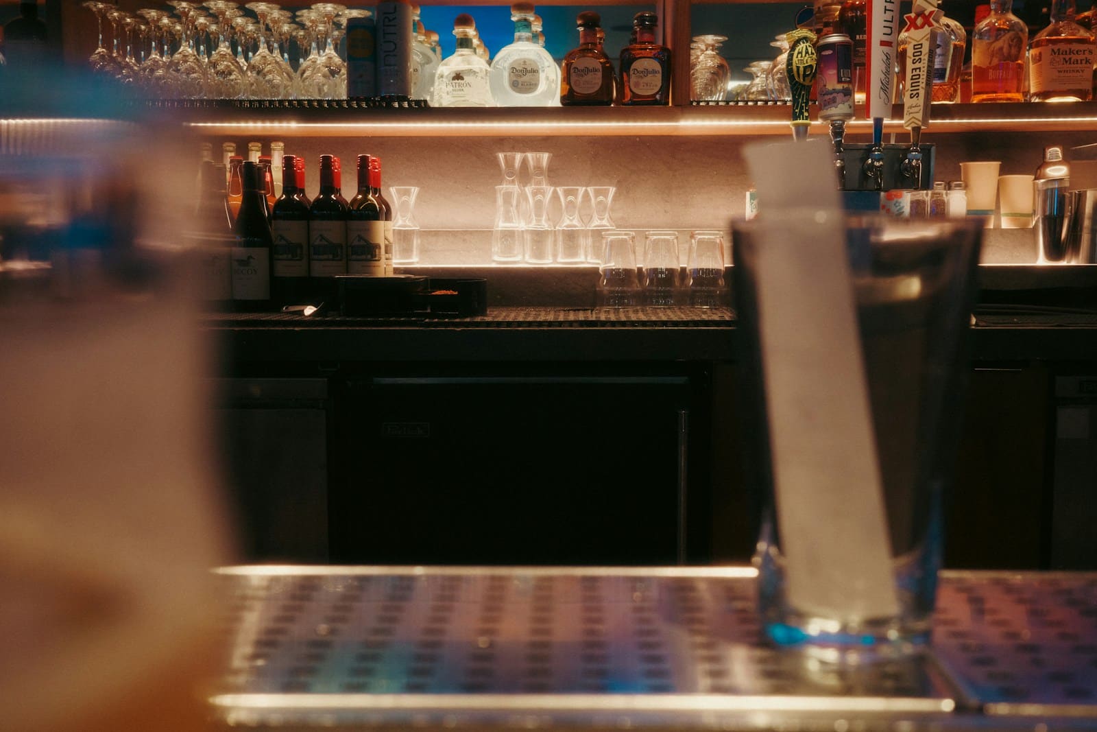 Bar counter lined with bottles and glasses