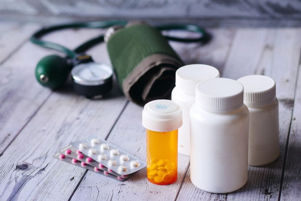 Pill bottles and a blood pressure monitor on a table