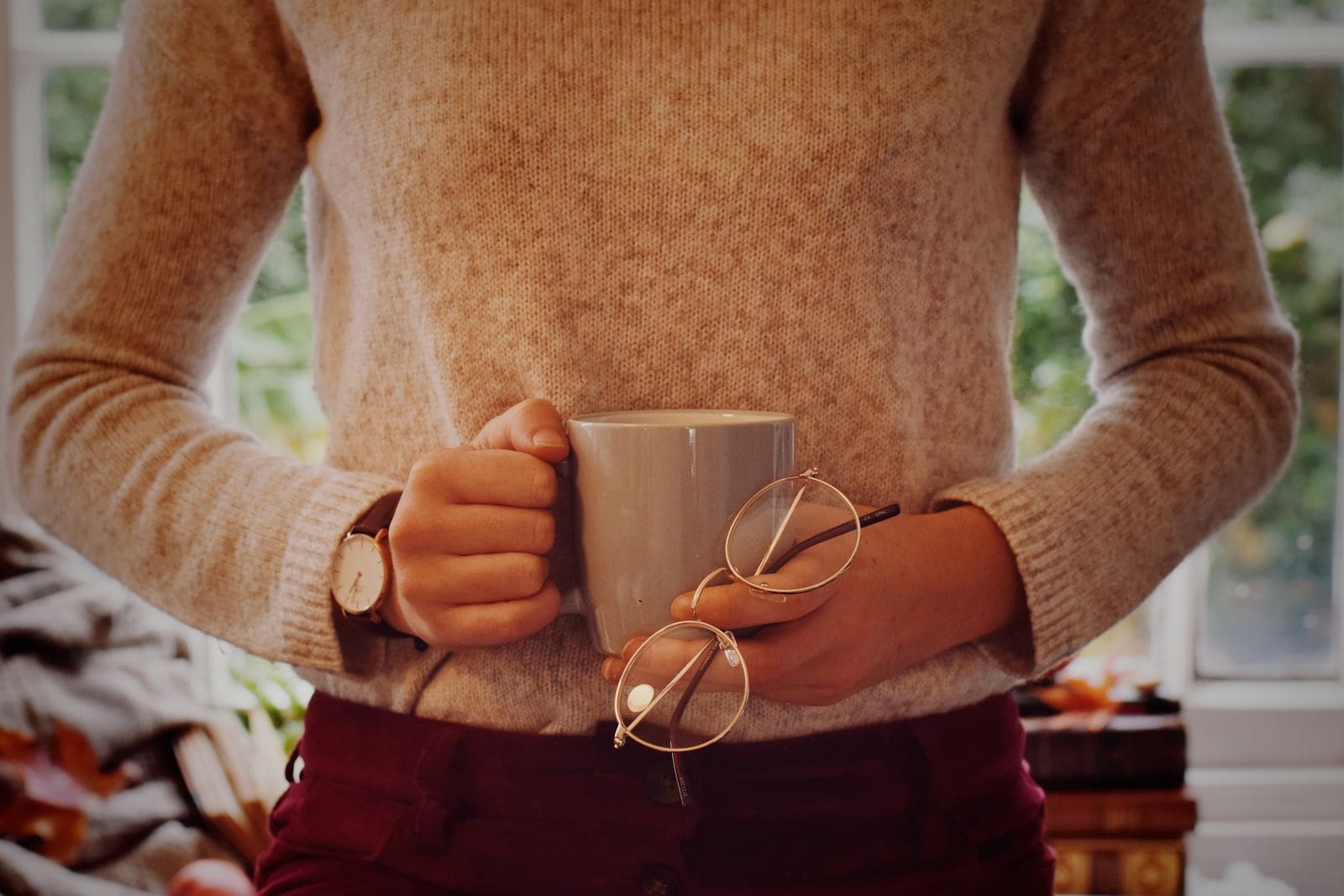 Hands holding a mug of coffee indoors