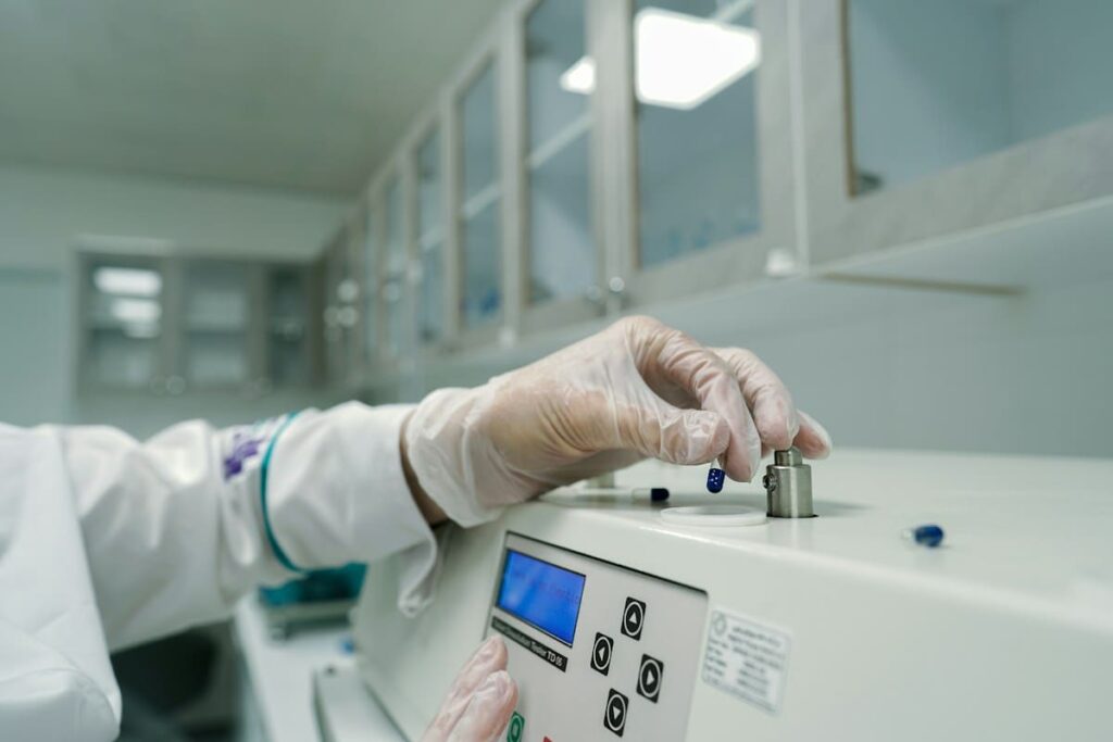 Laboratory worker in gloves operating a testing machine