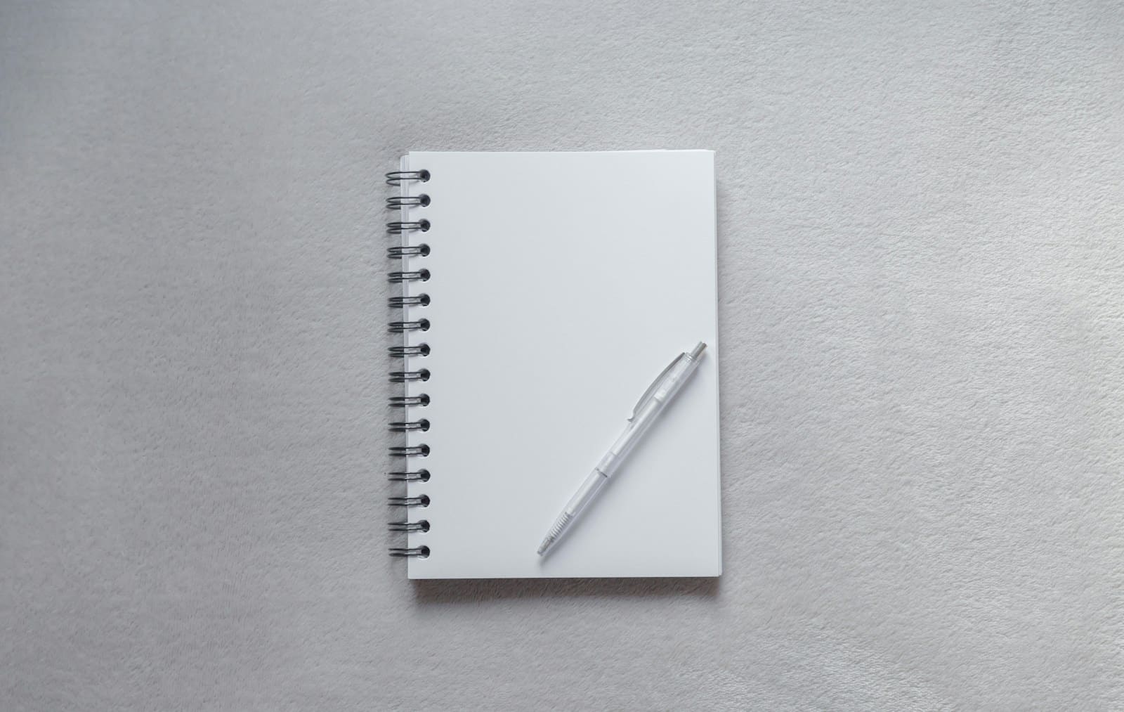 White notebook with a pen on top