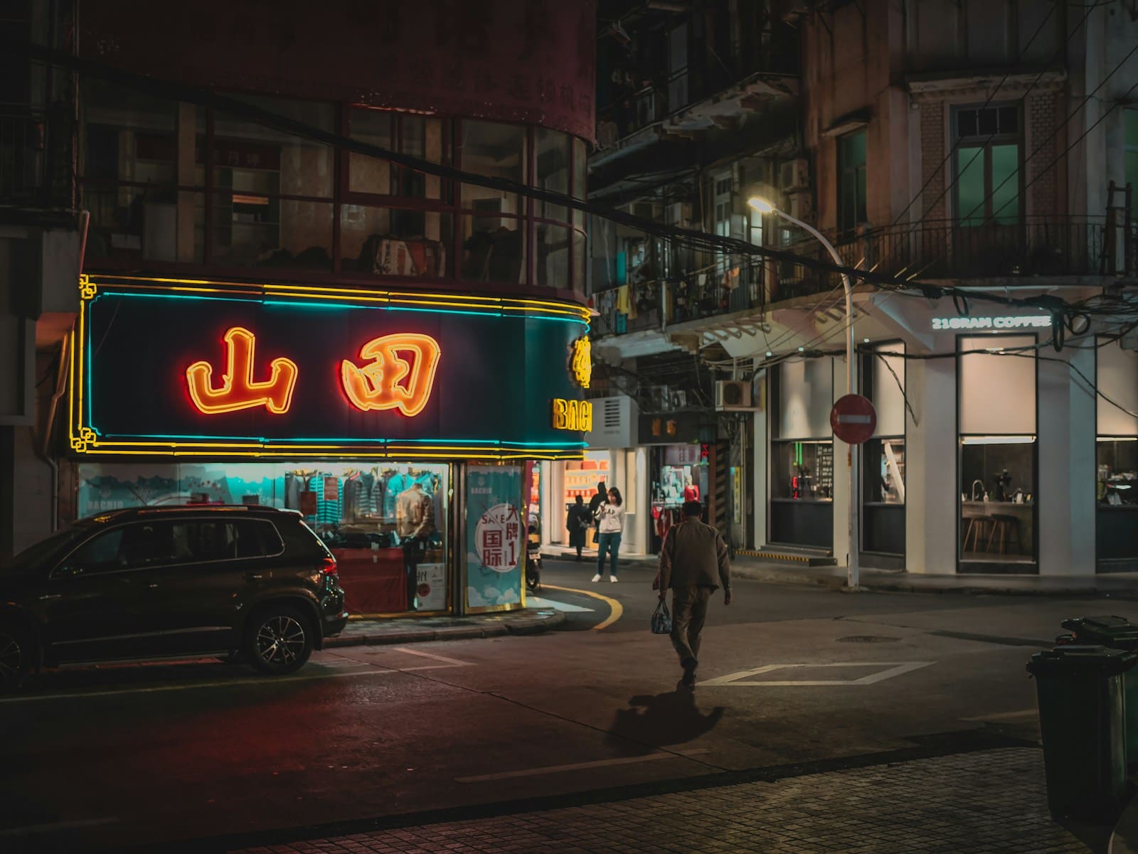Neon shop sign glowing on a city street at night