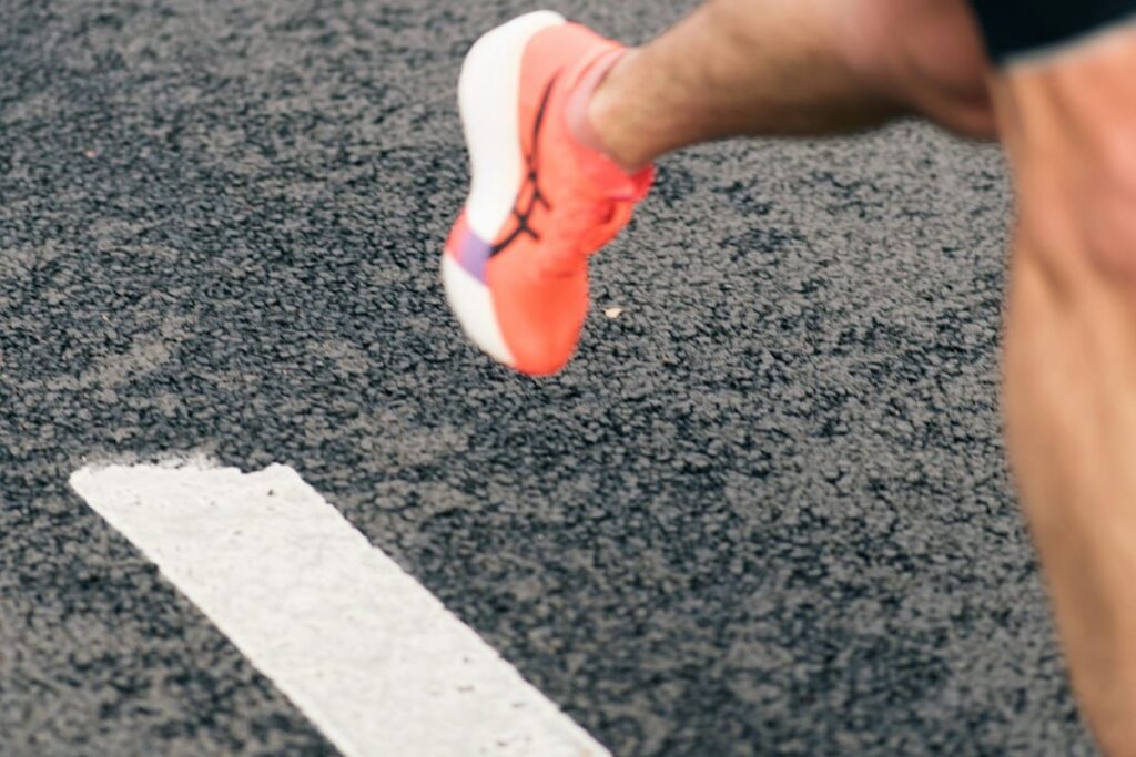 Runner's foot crossing a white line on a track