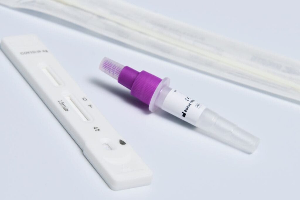 Test kit with a swab and dropper on a white surface