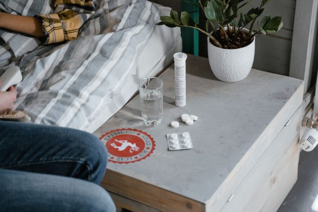 Bedside table with medication and a glass of water