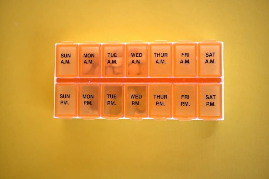 Orange weekly pill organiser with a compartment for each day
